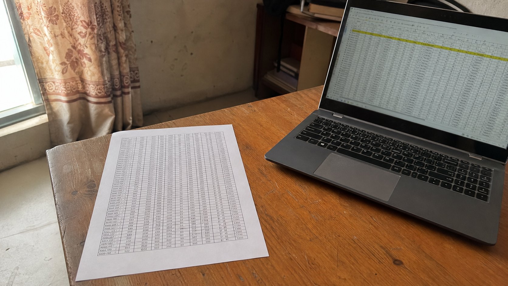 A printed spreadsheet on one A4 sheet beside a laptop.