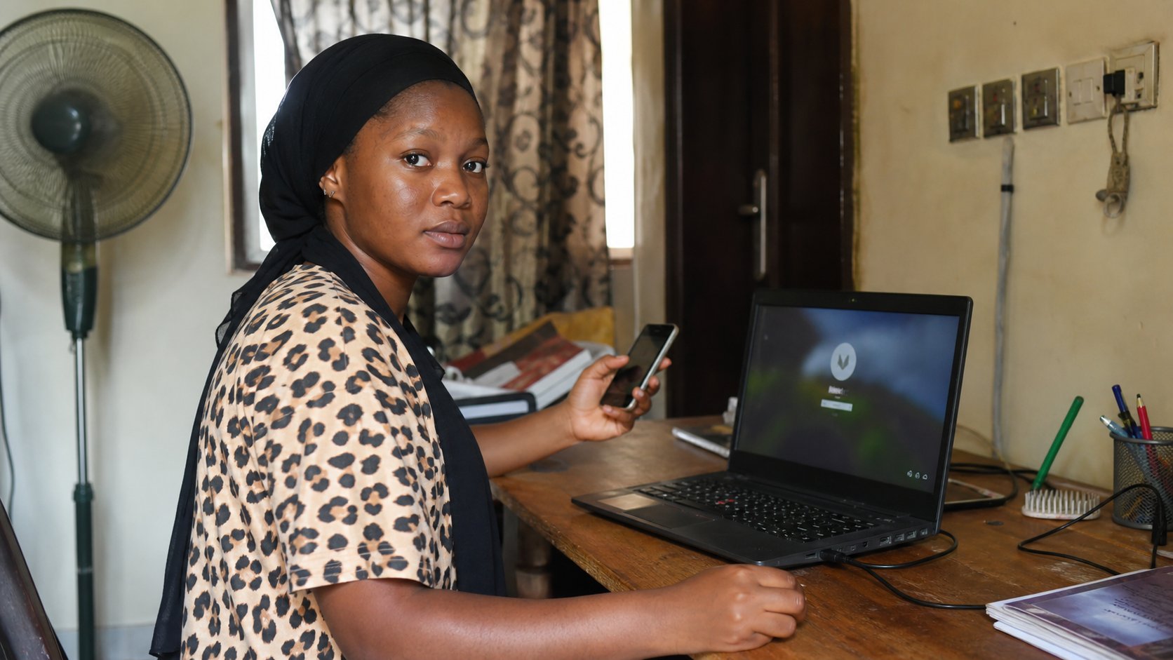 A learner with a laptop login and a phone, waiting for a code.