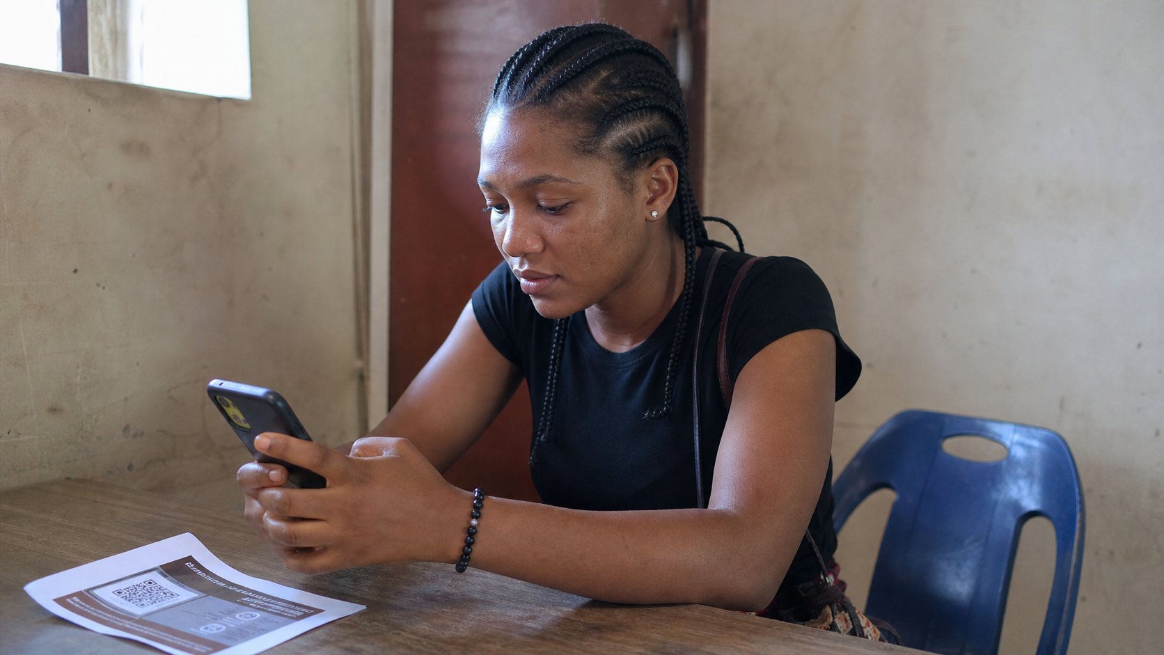 A young woman looking at a phone after scanning a flyer.