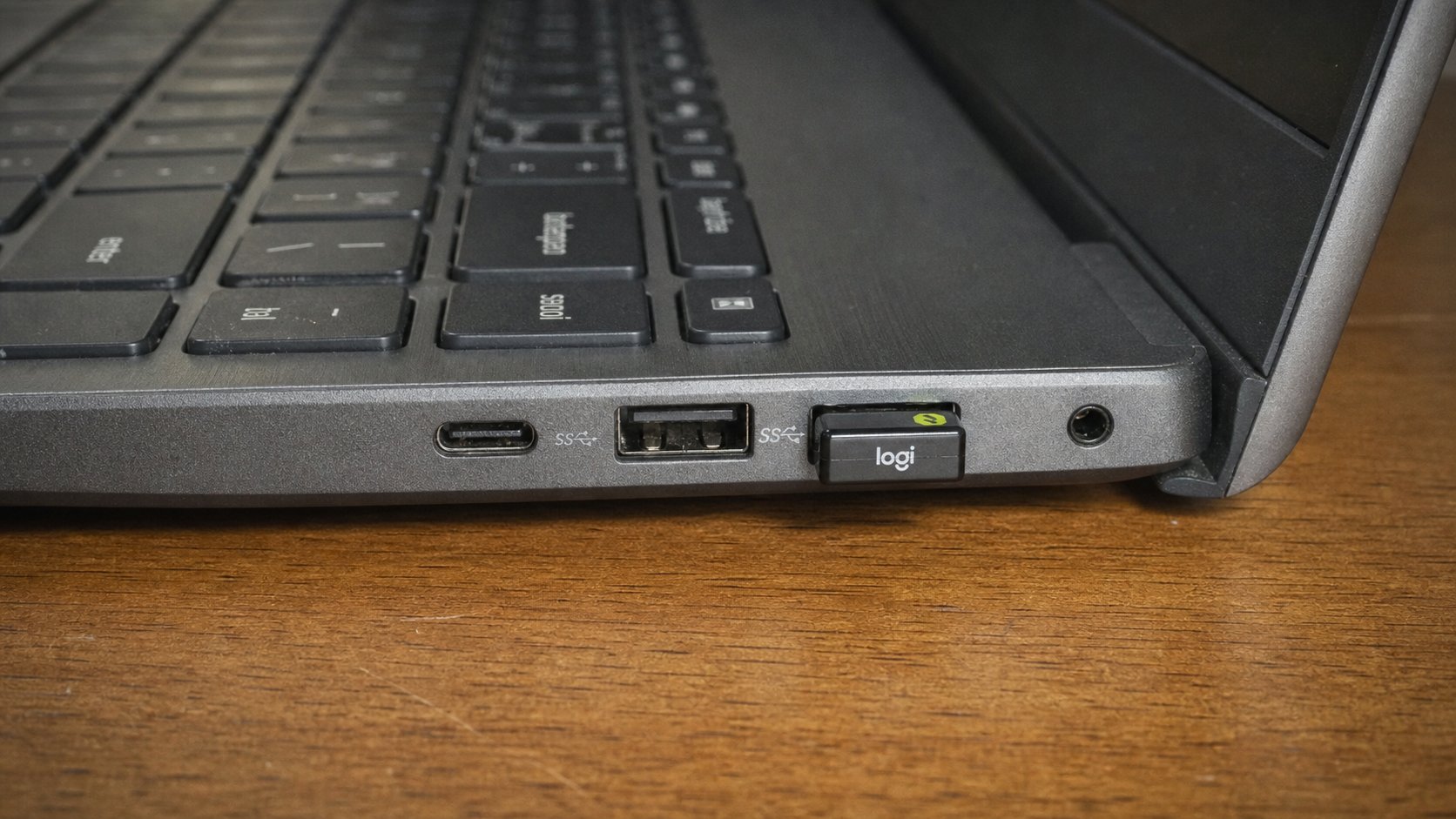 USB ports on the side of a laptop with a small dongle plugged in.