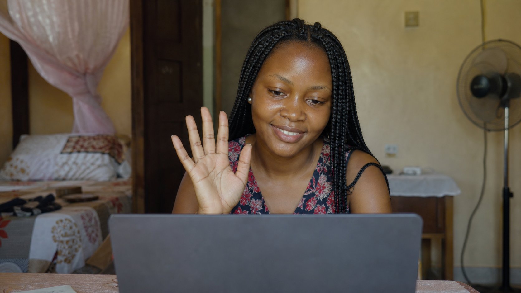 A young woman in a camera preview on a laptop.